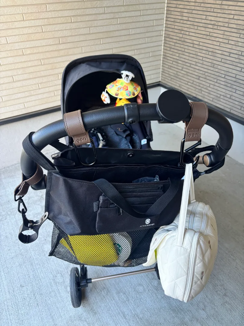 ベビーカーフックに掛けたベビーカーバッグとポーチ、下の荷物入れ
