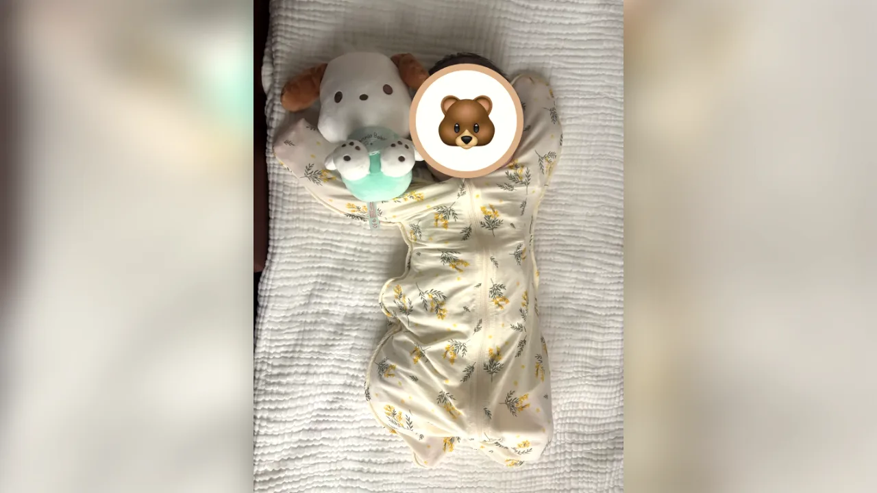 コニー(Konny)のスワドルスーツ(ミモザ柄)を着た赤ちゃん|腕を上げたバンザイの形